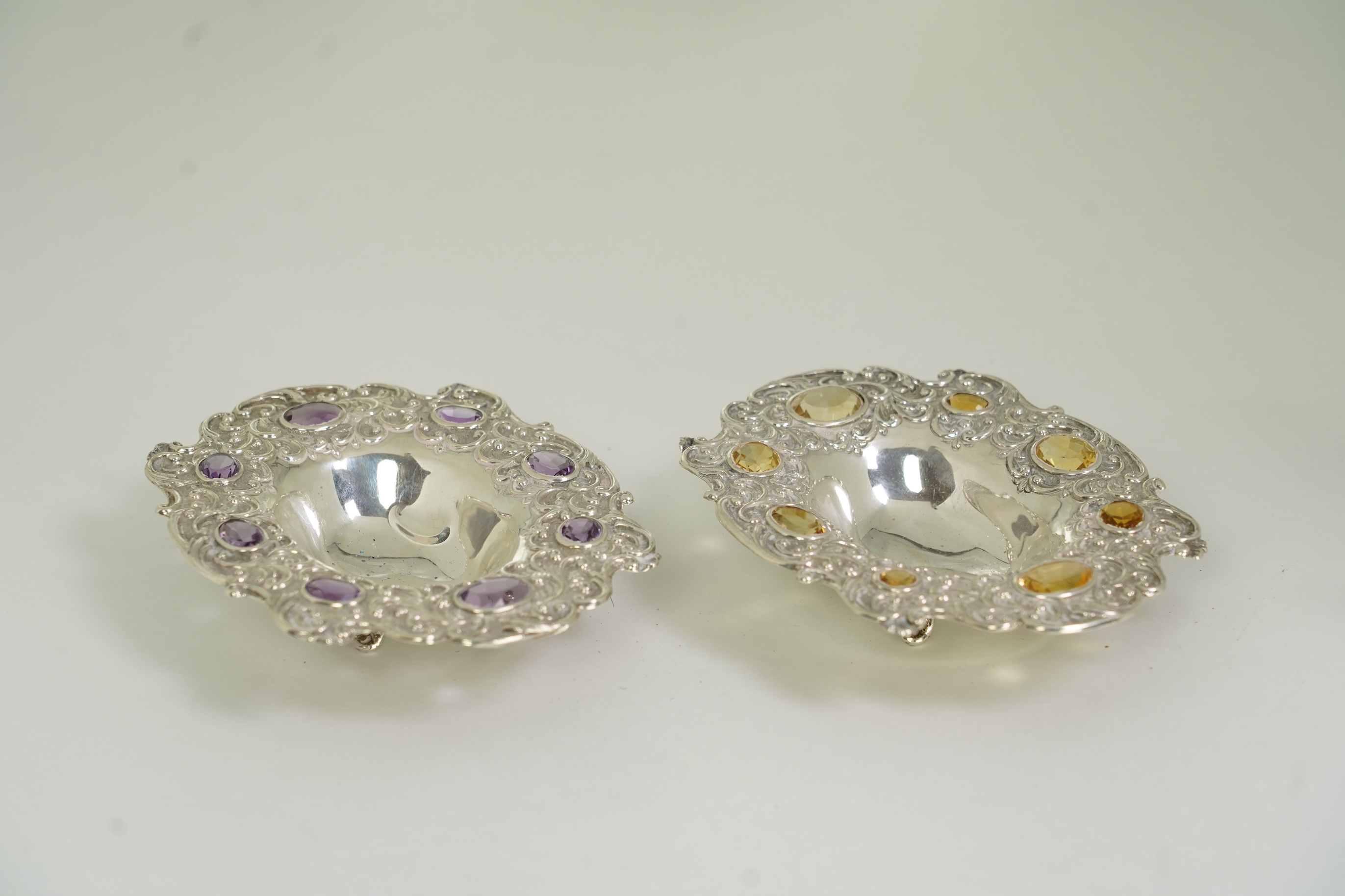 Two unusual late Victorian repousse silver dishes, by Daniel & John Welby, one border inset with eight oval cut amethysts, the other with eight oval cut citrines